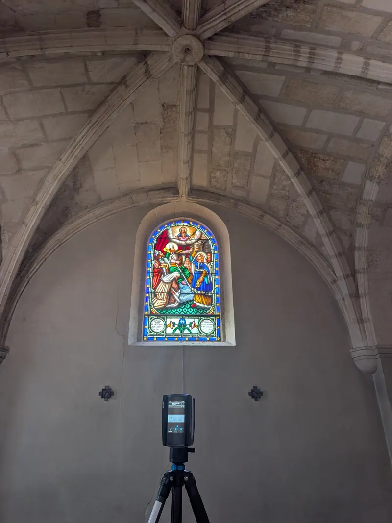 Scanner laser sur trepied dans l'eglise d'Arbanats, devant une verriere